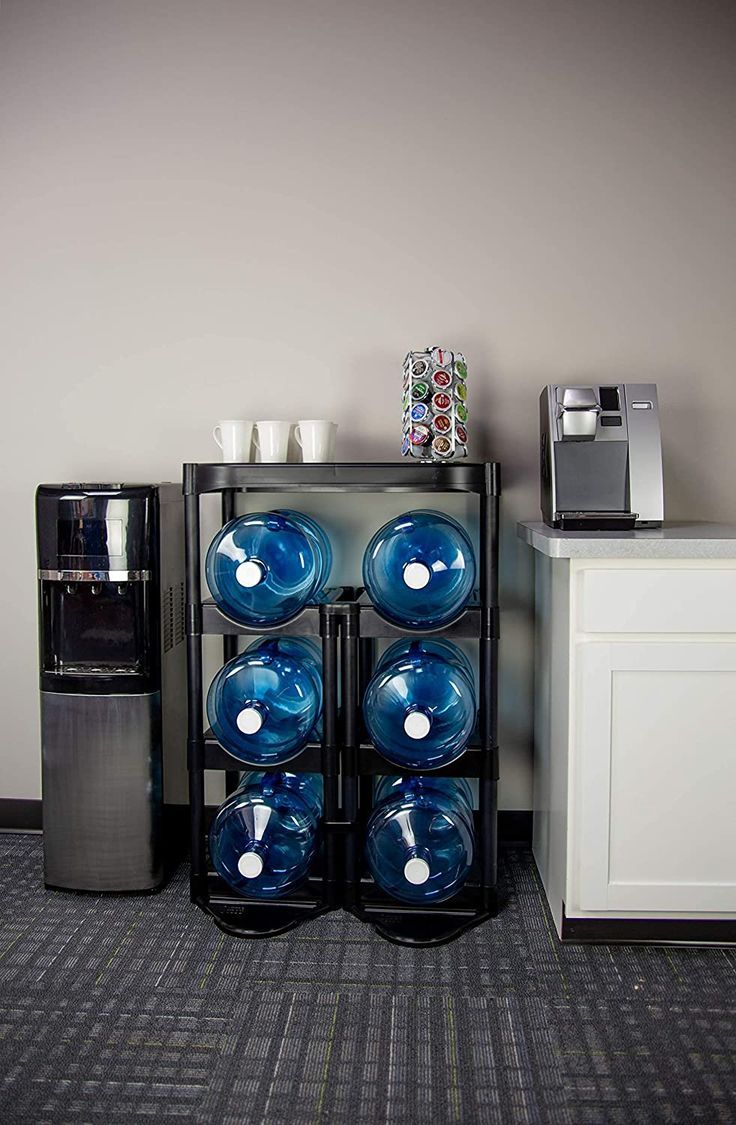 there is a coffee maker and several cups on the shelf next to each other in this room