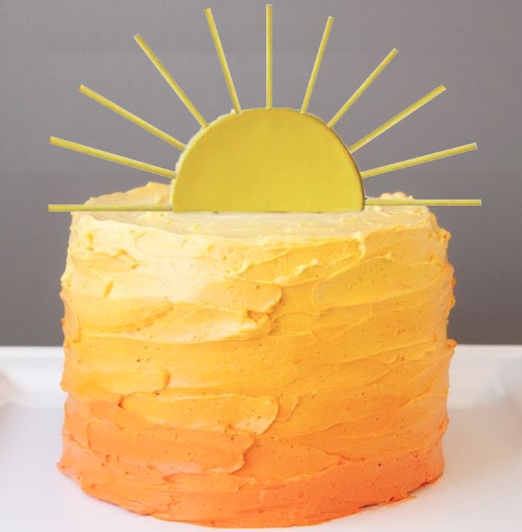 a cake with yellow frosting and a sun decoration on top