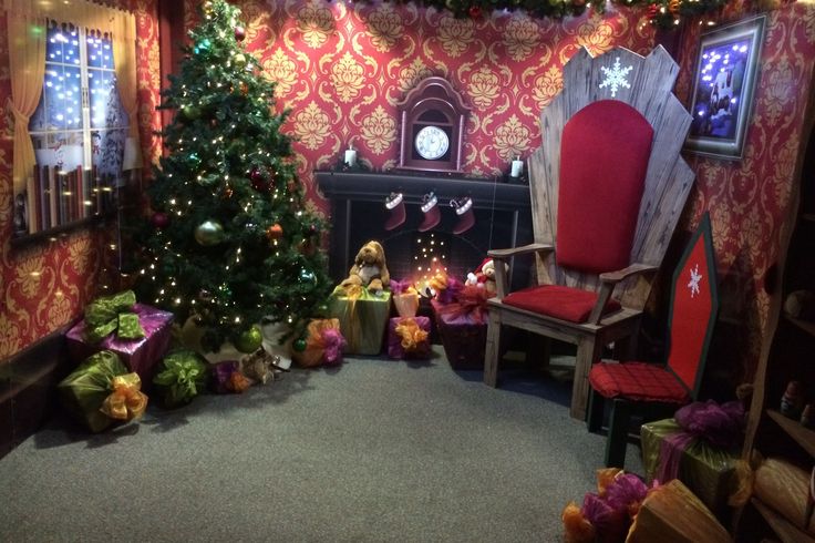 a living room decorated for christmas with presents on the floor and a tree in the corner