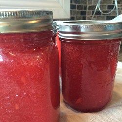 two jars filled with red liquid sitting on top of a table