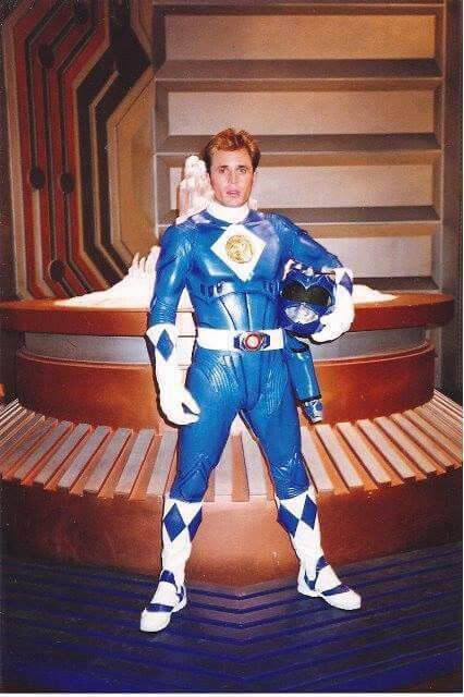 a man dressed in a blue and white costume posing for a photo with his hands on his hips