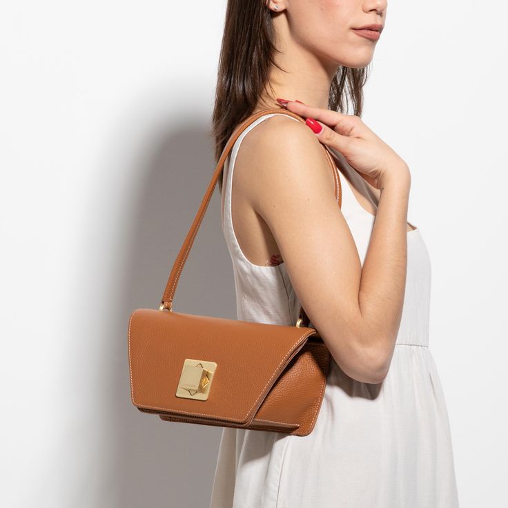 The Arcadia Trapeze combines geometric lines and an oversized front turn lock to create a contemporary style yet chic. A desing that stands out and matches perfectly with evening outfits. Modern Geometric Shoulder Bag With Removable Pouch, Modern Rectangular Box Bag With Magnetic Closure, Luxury Structured Bag With Fold Over Clasp, Modern Structured Bag With Magnetic Closure, Modern Shoulder Bag With Turn-lock Closure For Formal Occasions, Modern Square Bags With Magnetic Closure, Modern Square Shoulder Bag For Evening, Modern Square Flap Bag With Detachable Strap, Modern Rectangular Flap Bag With Detachable Handle