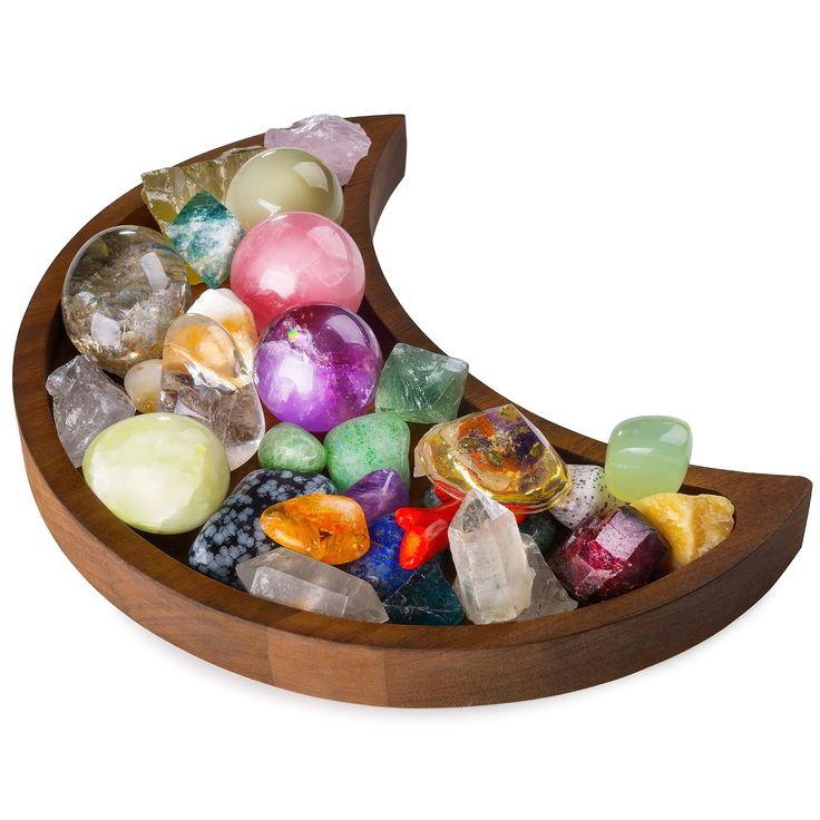 a wooden boat filled with lots of different colored rocks and gems on top of it