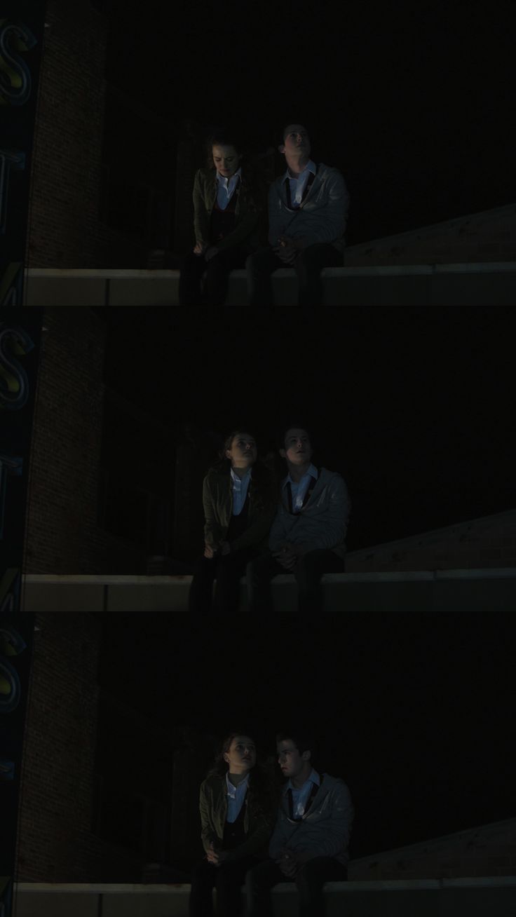 two men sitting in the dark with their hands on their hipss and looking at something