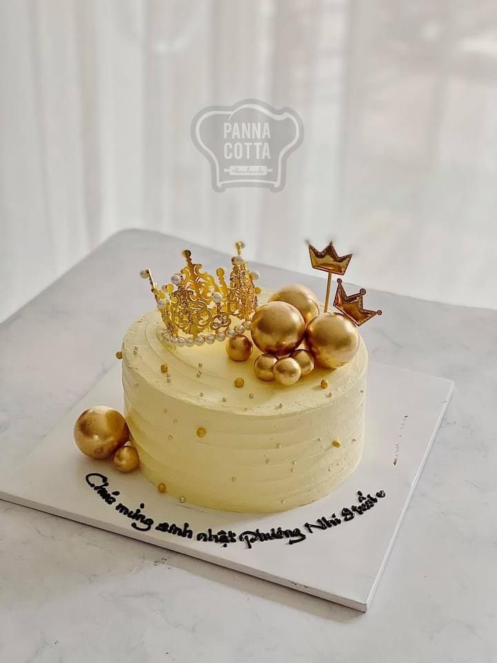 a white cake with gold decorations on top