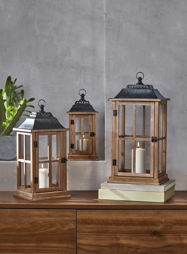 two wooden lanterns sitting on top of a dresser