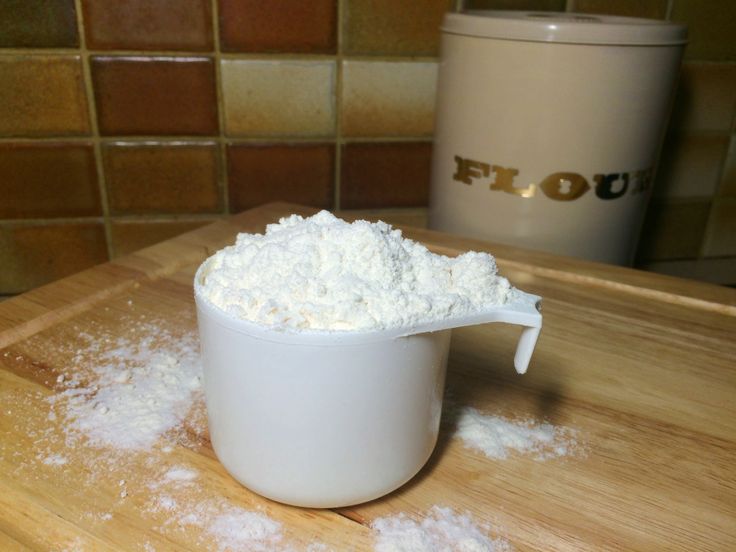 powdered sugar in a measuring cup on a cutting board