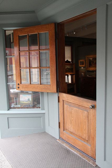 an open door to a room with wooden paneling and glass panels on the windows