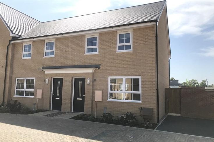 a two story brick house with white windows