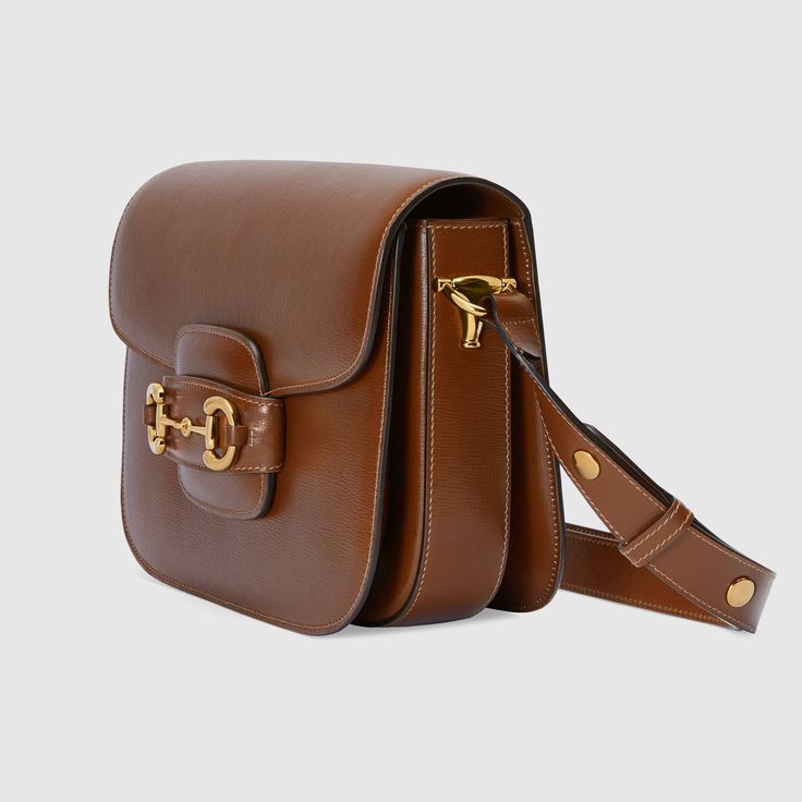 Description Introduced for Cruise 2020, the Gucci 1955 Horsebit bag is recreated from an archival design. With the same lines and forms first introduced over six decades ago, the accessory unifies the original details with a modern spirit, highlighting the Horsebit. Part of Gucci’s genetic code, the double ring and bar design has been established as one of the most distinctive elements among the House symbols borrowed from the equestrian world. Presented on a small flap shoulder bag, the hardware is paired with textured white leather and completed with a special mechanism that adjusts the length of the shoulder strap so it can be carried on one shoulder or crossbody. Size: 9.8″W x 7″H x 3.1″D / W25cm x H18cm x D8cm 100% genuine materials, matching the quality of the Gucci product; Brown te Travel Buddies, Classic Purse, Bags Ideas, Modest Maxi, Gucci Horsebit, Cat Bag, Bag Collection, Designer Handbag, Small Pouches