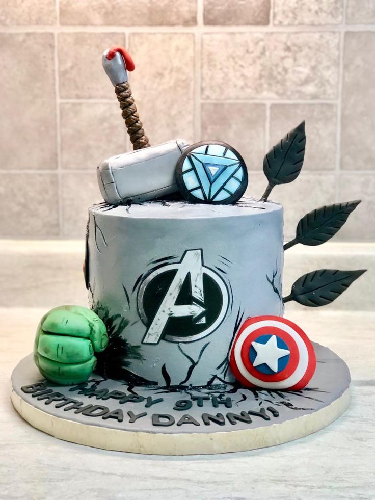 the avengers birthday cake is decorated with iron man, captain america and thor's hammer