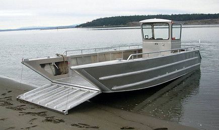 a boat sitting on top of a sandy beach next to the ocean with stairs leading up to it