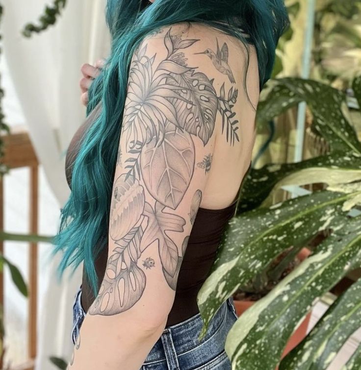 a woman with green hair and tattoos on her arm