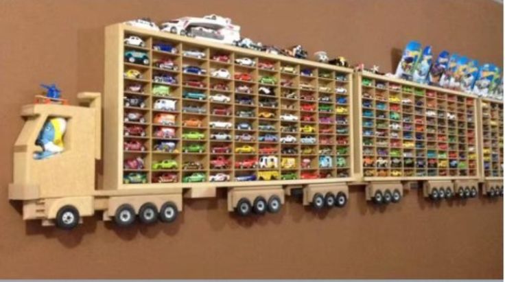 a wooden shelf filled with lots of toy cars on top of it's sides