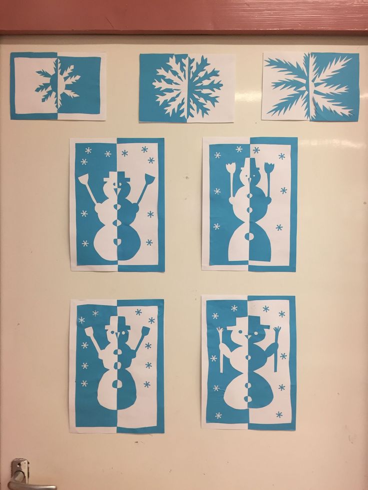 four snowmen are shown in blue and white paper cutouts on the wall above them