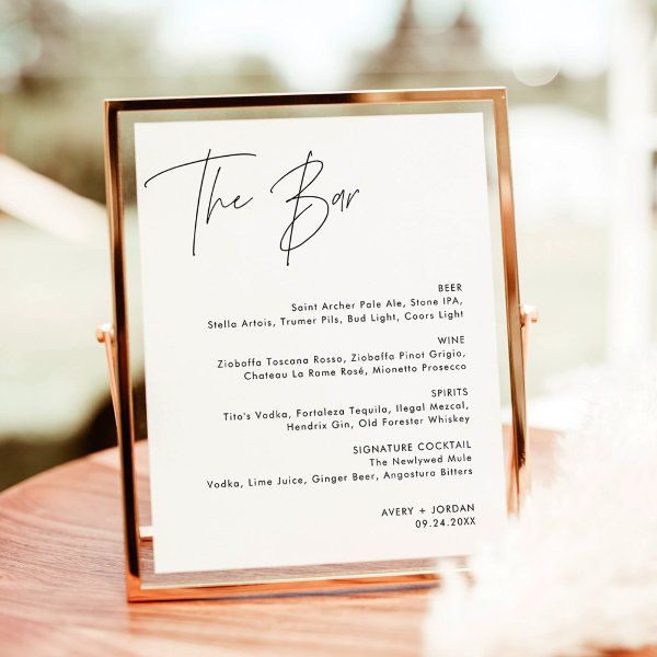 a table with a sign that says the bar on it and some feathers in front of it