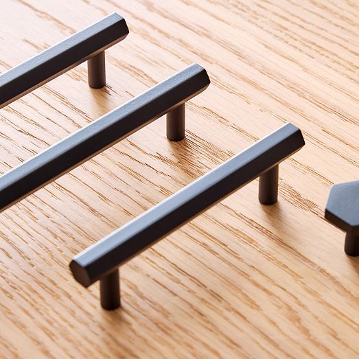 three metal handles on a wooden surface