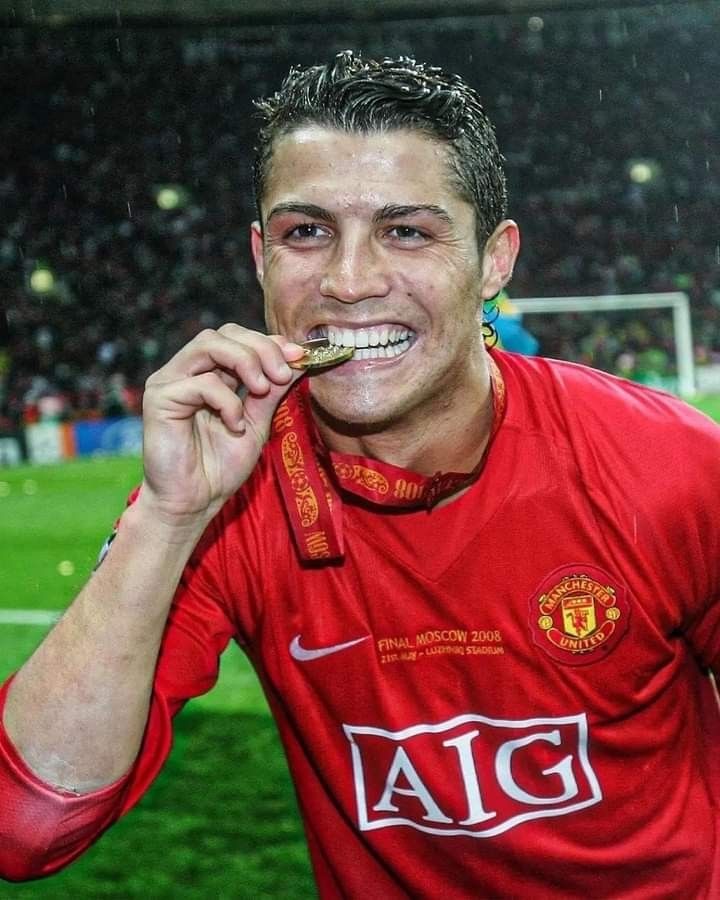 a man in red shirt brushing his teeth with tooth brush on soccer field at night