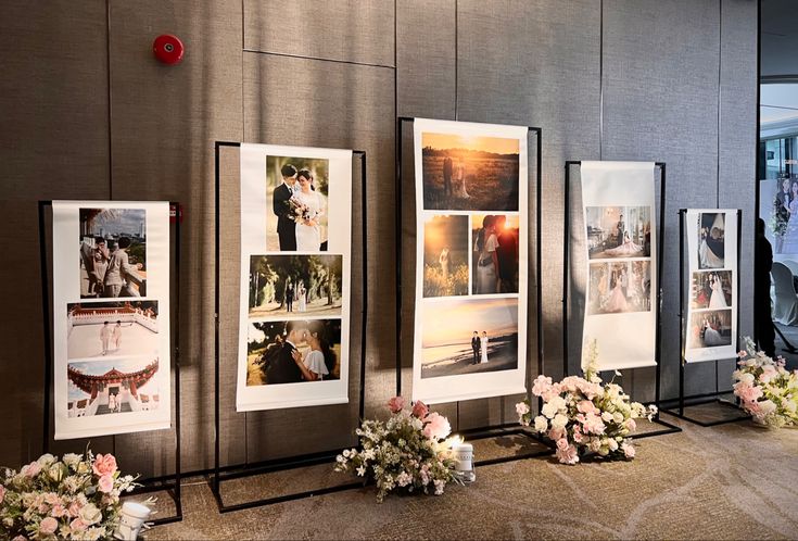 flowers and pictures on display in front of a wall