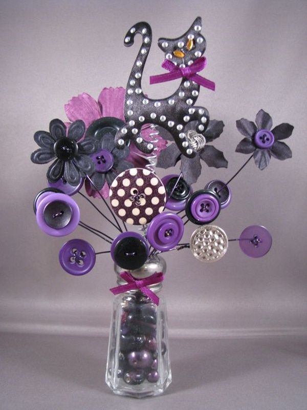 a vase filled with buttons and flowers on top of a table