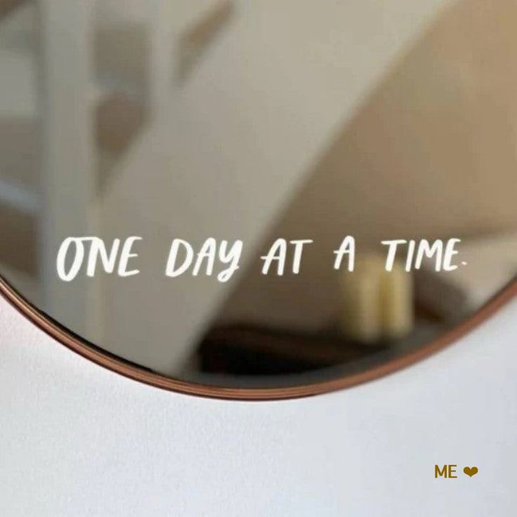 a mirror with the words one day at a time written in white lettering on it