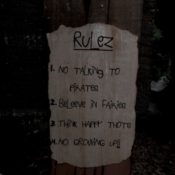 a sign posted on a wooden post stating rules