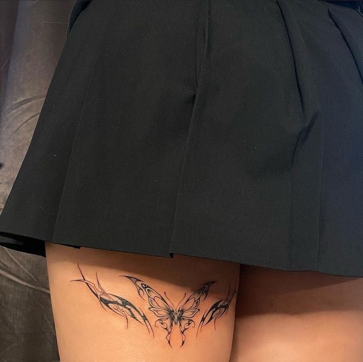 a woman with a butterfly tattoo on her thigh