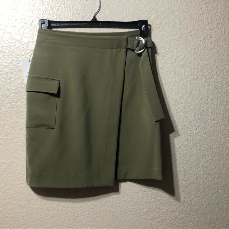 New Olive Green Skirt. New Condition. Casual Asymmetrical Mini Skirt For Workwear, Chic Green Skort For Fall, Trendy Asymmetrical Skort For Work, Spring Asymmetrical Skort With Pockets, Casual Belted Skort For Work, Green Mini Skirt For Work, Green Mini Skirt For Workwear, Spring Workwear Green Mini Skirt, Spring Workwear Belted Skort