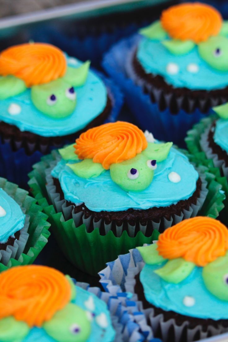 cupcakes with blue frosting and green icing decorated like an orange fish