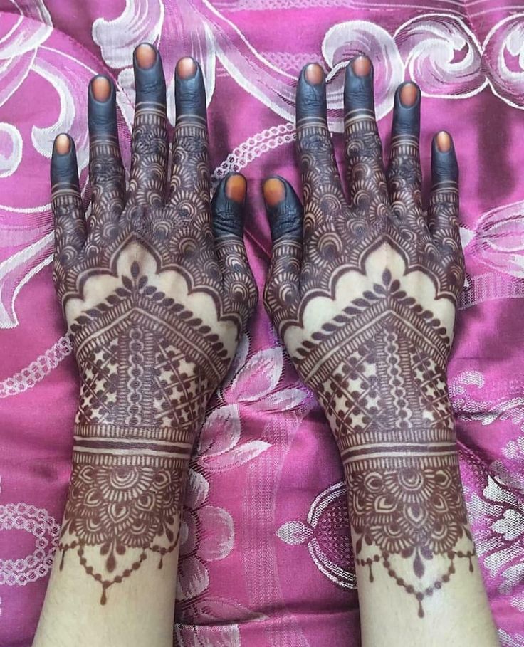 two hands with henna designs on them