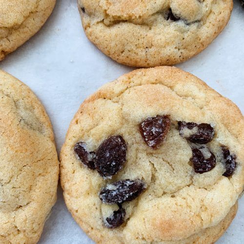 four cookies with raisins and chocolate chips on top