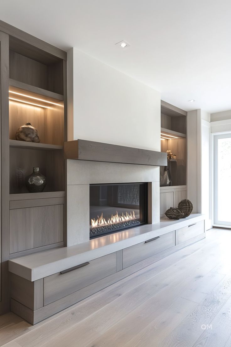 a modern fireplace in the middle of a living room with built - in shelving