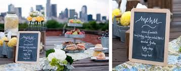 a table topped with cakes and desserts next to a chalkboard sign that says menu