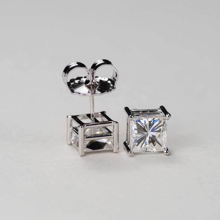 Our princess cut Charles & Colvard Forever One® colorless moissanite 4-prong stud earrings are a must have for every woman's jewelry box. Get the look and durability of diamonds, without the high cost and environmental footprint. Available in 14k, 18k yellow, white and rose gold as well as platinum. Choose desired metal and stone size from the drop-down menus before checkout. If you want these made with GIA certified diamonds, colored gemstones, or different moissanite shapes, please contact Luxury Heart Cut Earrings With Prong Setting, Gift Moissanite Diamond Earrings With Prong Setting, White Gold Asscher Cut Jewelry With Prong Setting, Asscher Cut White Gold Jewelry With Prong Setting, Luxury Moissanite Diamond Earrings As Gift, Asscher Cut Cubic Zirconia Diamond Earrings With Prong Setting, Formal Heart-cut Diamond Earrings With Prong Setting, Sterling Silver Classic Cut Fine Jewelry, Gia Certified Asscher Cut White Gold Jewelry