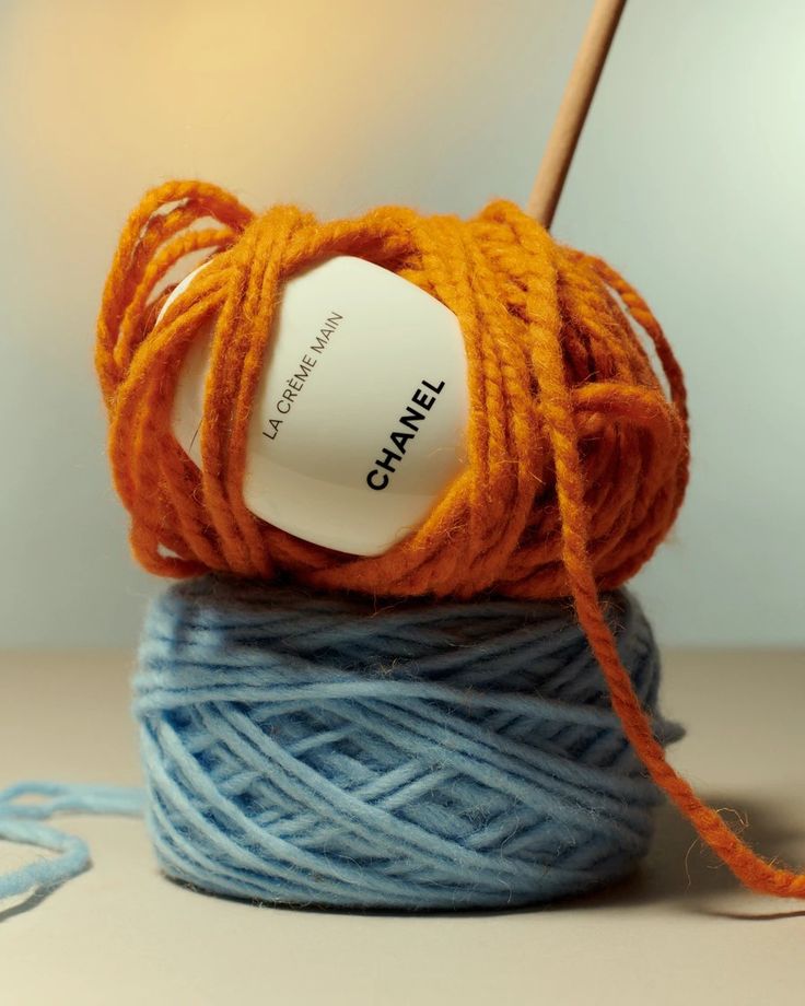 an orange ball of yarn sitting on top of a blue skeine