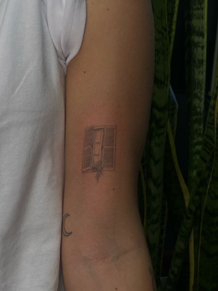 a person with a book tattoo on their arm