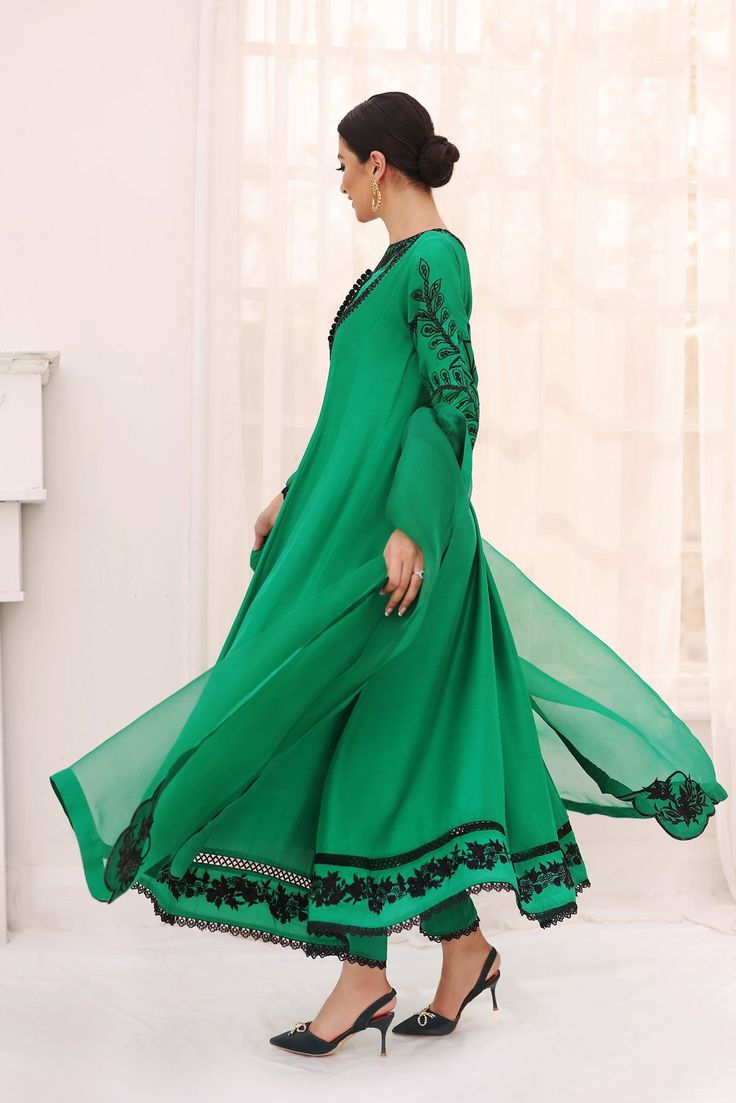 Canvassed on a long pure raw silk emerald green hue with hand embroidered details in a flowy pishwas silhoutte, the sleeves feature a cutwork motif and the hem is adorned with an intricate floral border. Accompanying this gorgeous design is a pure organza embroidered dupatta alongside matching straight lacey trouser. T Green Dresses With Intricate Embroidery And Traditional Drape, Elegant Semi-stitched Green Sharara, Bollywood Green Dress With Floral Embroidery, Green Bollywood Dress With Floral Embroidery, Green Anarkali Sets With Intricate Embroidery, Green Embroidered Anarkali Dress, Fitted Green Salwar Kameez With Intricate Embroidery, Fitted Green Anarkali Set With Intricate Embroidery, Green Georgette Sets With Intricate Embroidery