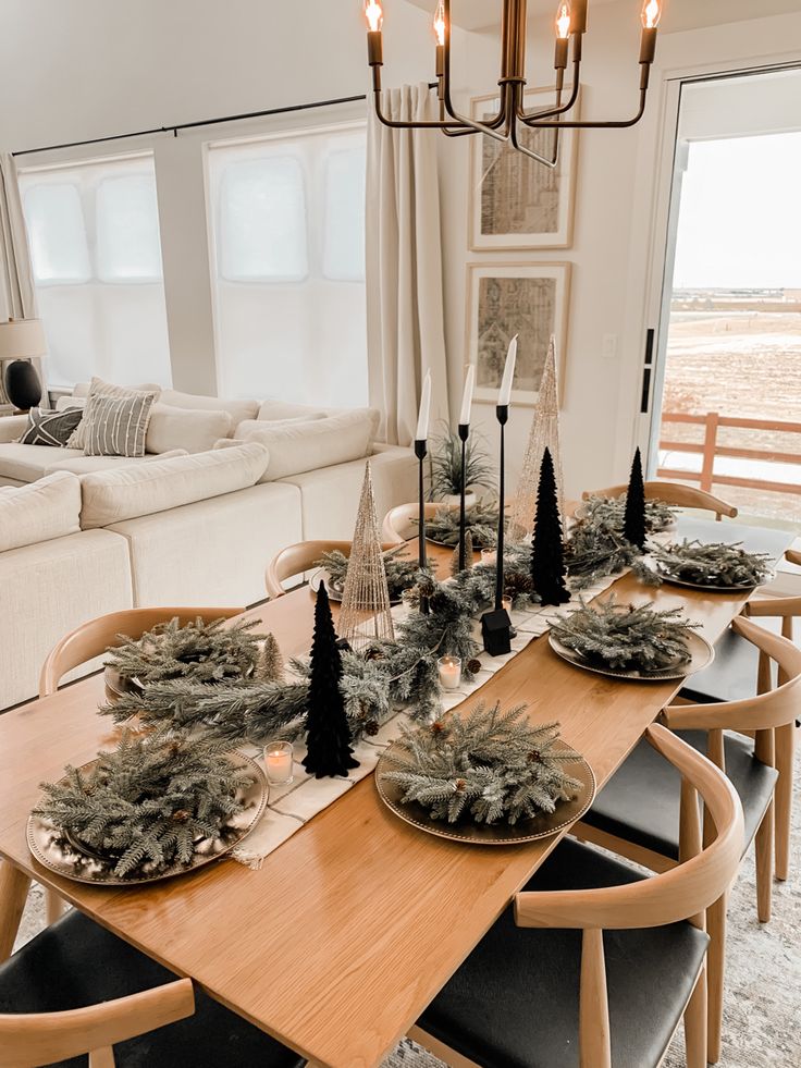 a dining room table is set for christmas with black and white decorations on the tables