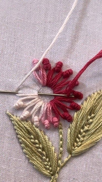 a close up of a piece of cloth with some thread on it and two flowers in the middle