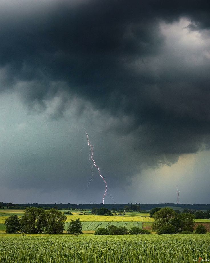 a lightning bolt is seen in the sky over a field