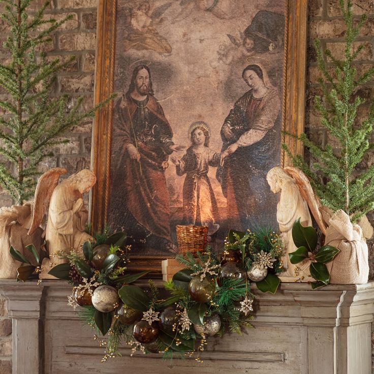 a mantel decorated with christmas decorations and greenery in front of a painting on the wall