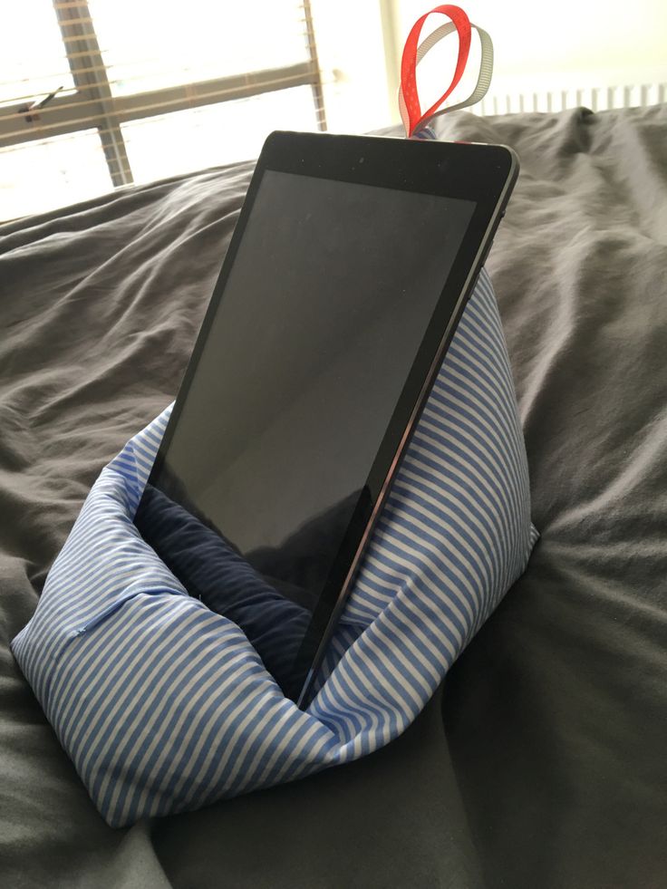 an electronic device sitting on top of a pillow in the middle of someone's bed