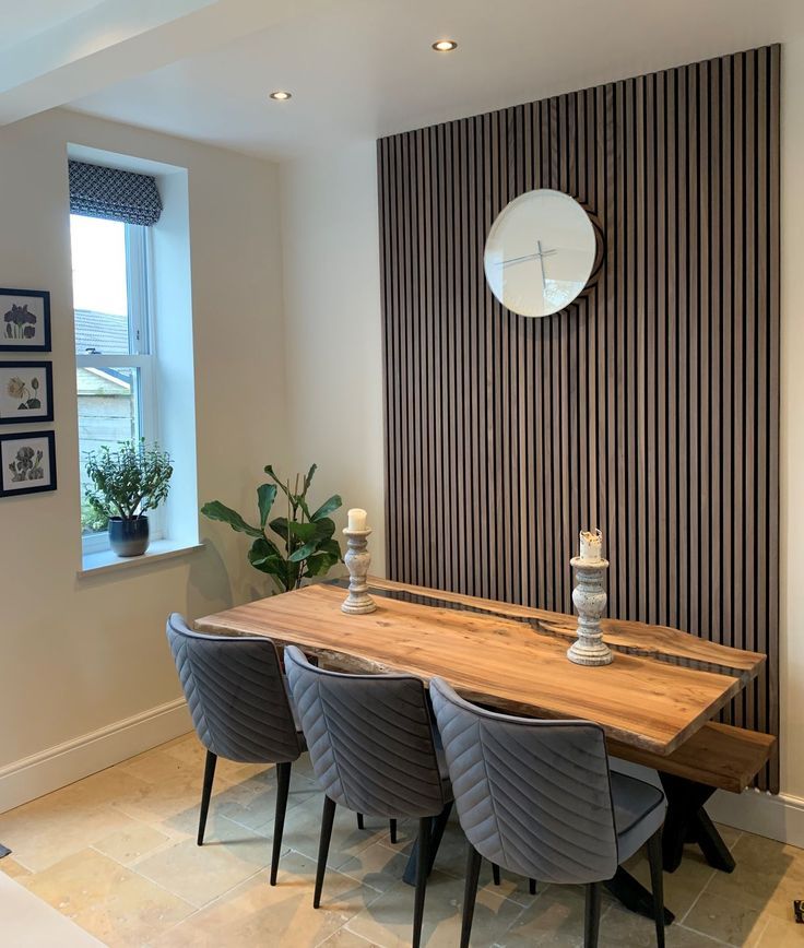 a dining room table with four chairs and a clock on the wall behind it that says naturewall