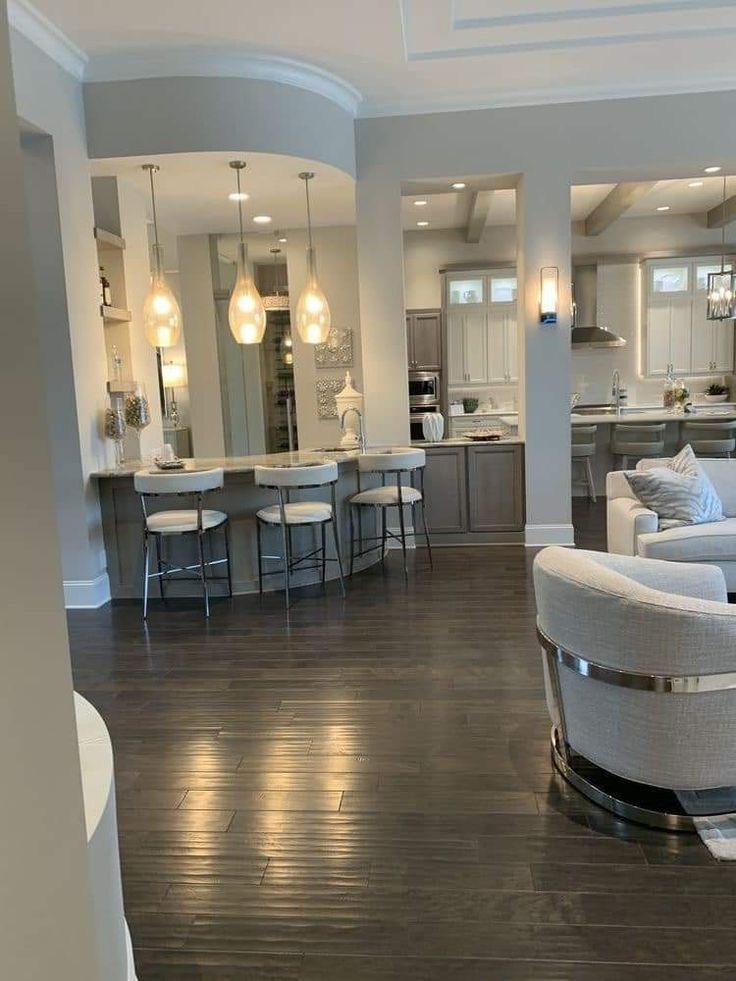 a living room filled with white furniture and lots of counter space next to a kitchen