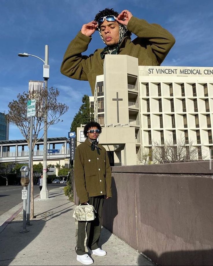 a man standing on the side of a road next to a tall building with a cross on it