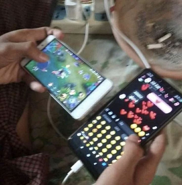 a person holding a cell phone in their hand and playing with an electronic game on the screen