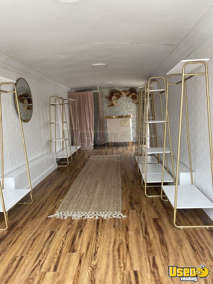 an empty room with white walls and wooden floors is shown in this image, there are mirrors on either side of the wall