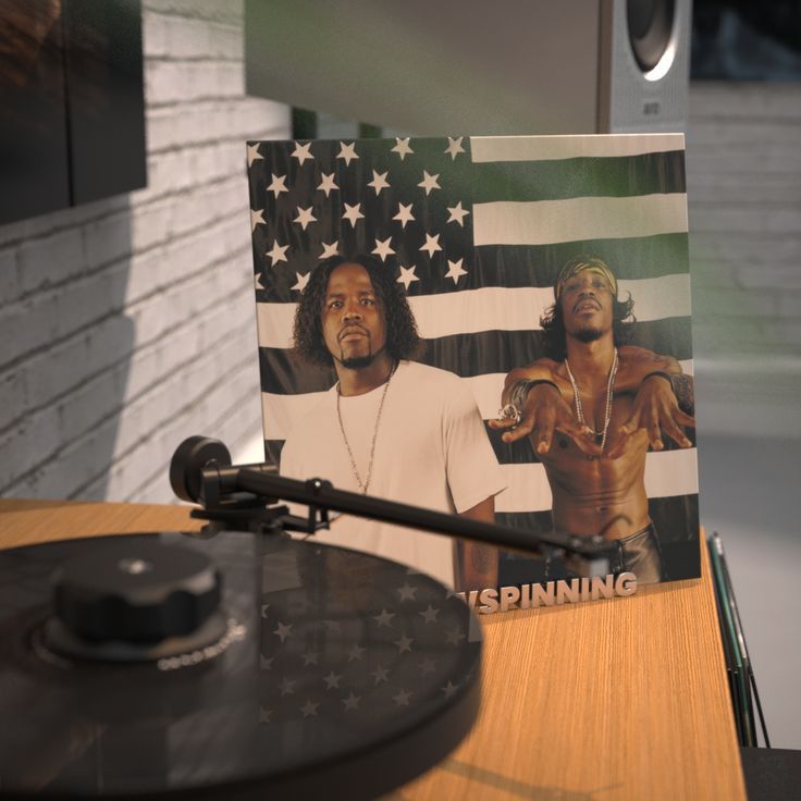 a record player sitting in front of an american flag with the image of two men on it