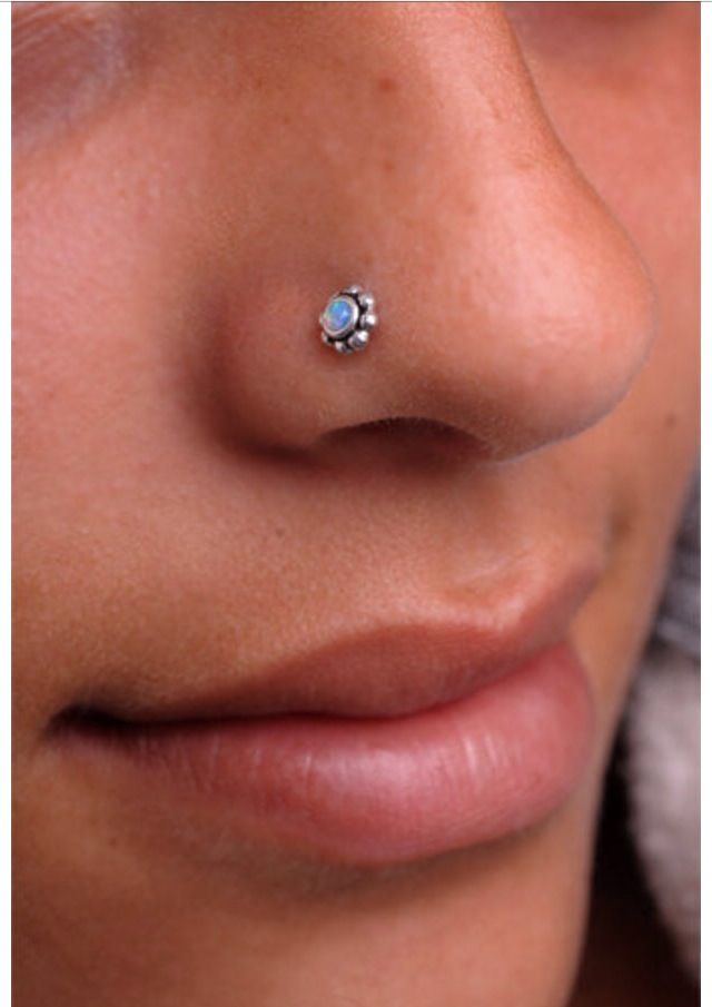 a woman's nose with a small piercing on top of her nose and the bottom part of her nose