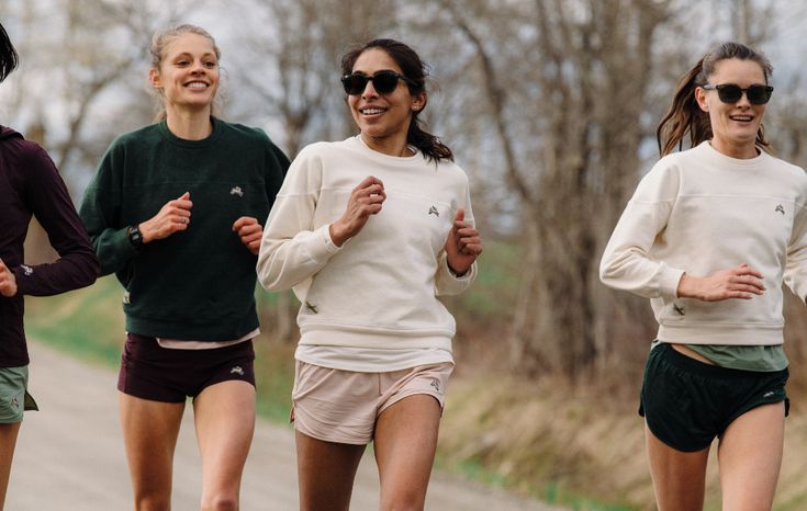 three women are running down the road in shorts and sweaters, both wearing sunglasses